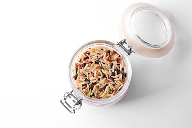 Photo of Mix of brown rice in jar isolated on white, top view