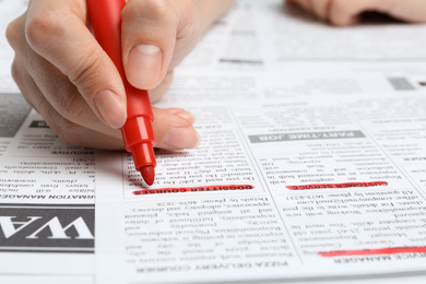 Woman marking advertisement in newspaper, closeup. Job search concept