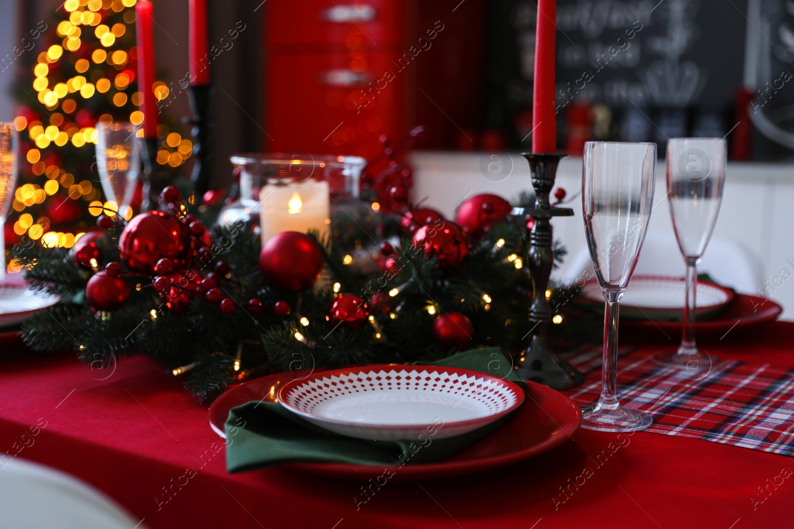 Photo of Table served for festive dinner and blurred Christmas tree in stylish kitchen interior, closeup