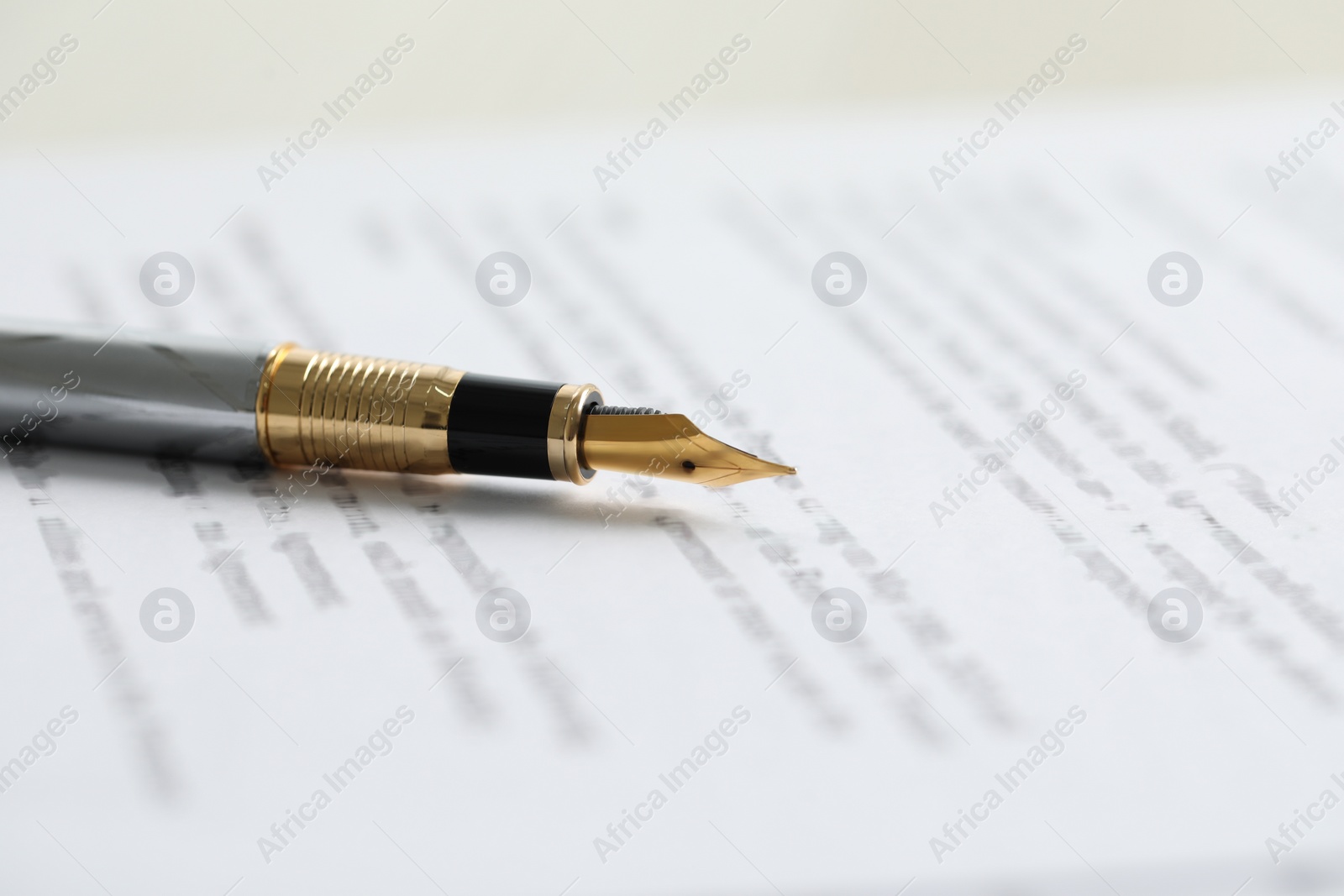 Photo of Fountain pen on paper document, closeup. Notary services