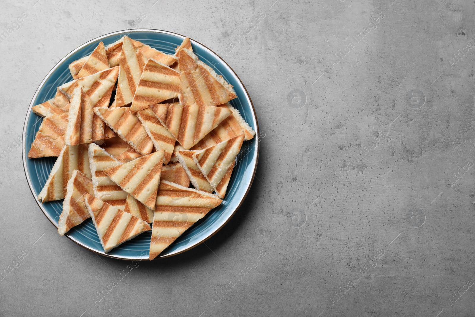 Photo of Delicious pita chips on grey table, top view. Space for text