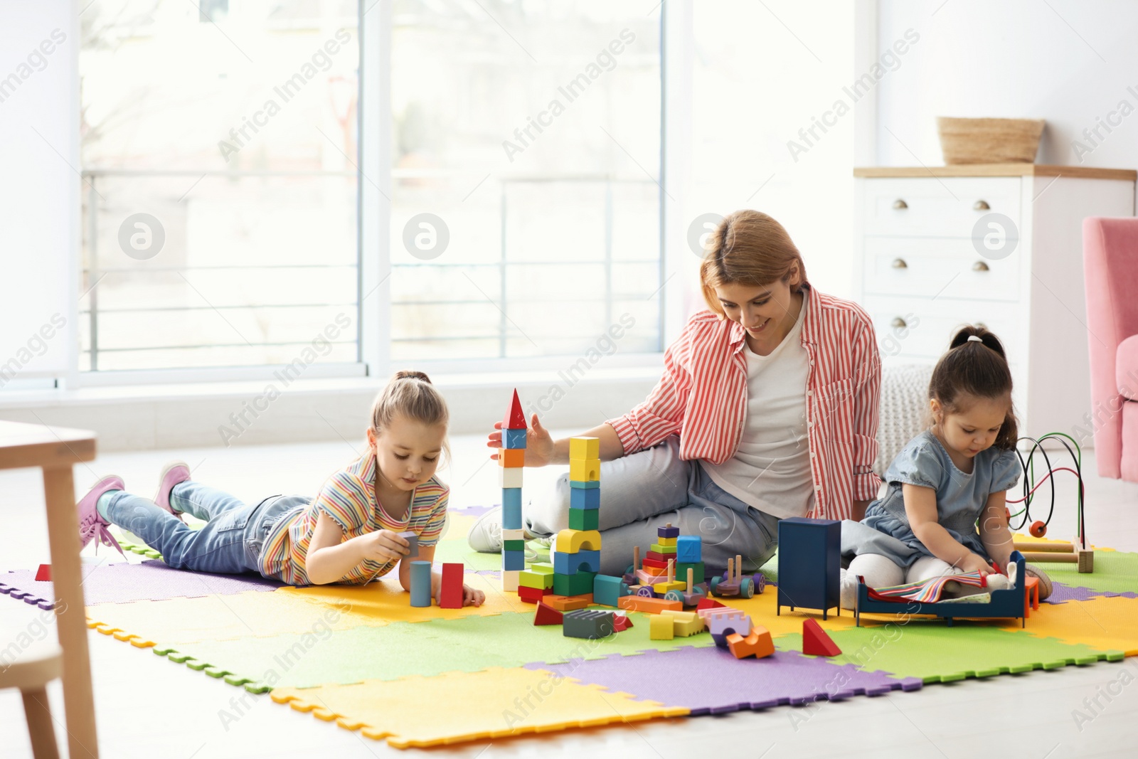 Photo of Mother playing with her children at home