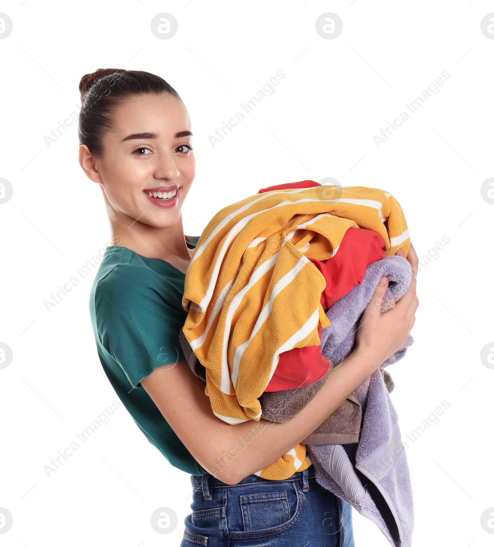 Photo of Happy young woman holding pile of dirty laundry on white background