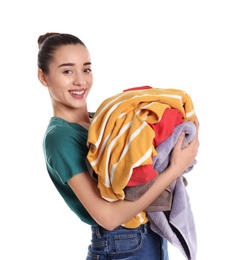 Photo of Happy young woman holding pile of dirty laundry on white background