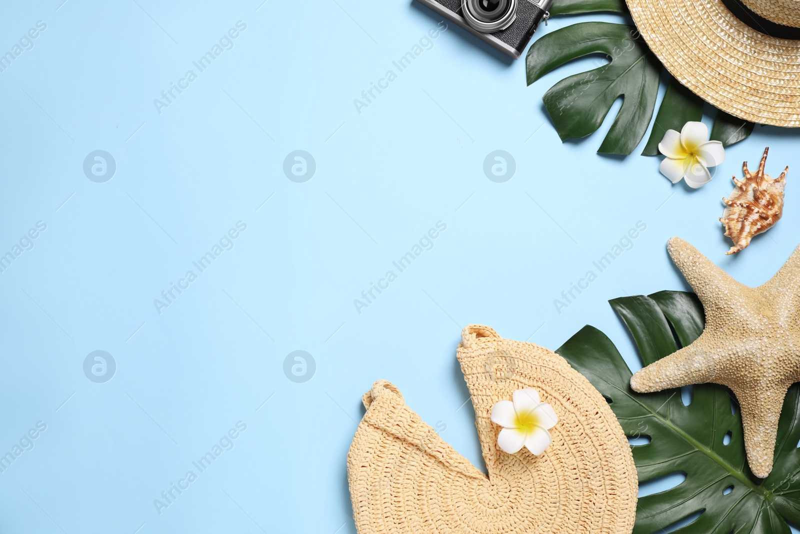 Photo of Flat lay composition with beach accessories on light blue background. Space for text