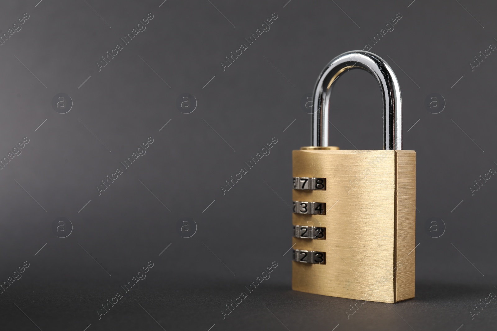 Photo of One steel combination padlock on dark grey background, closeup. Space for text