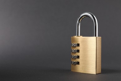 Photo of One steel combination padlock on dark grey background, closeup. Space for text