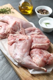 Photo of Fresh raw rabbit legs on black table, closeup