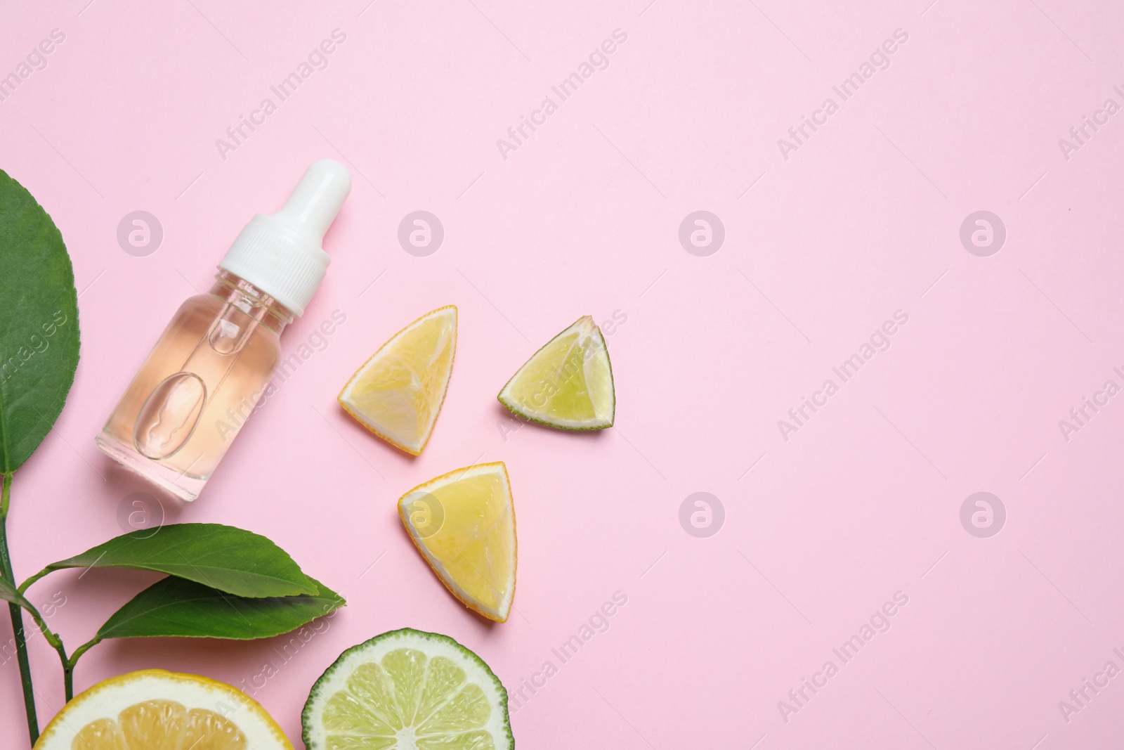 Photo of Flat lay composition with bottle of citrus essential oil on pink background. Space for text