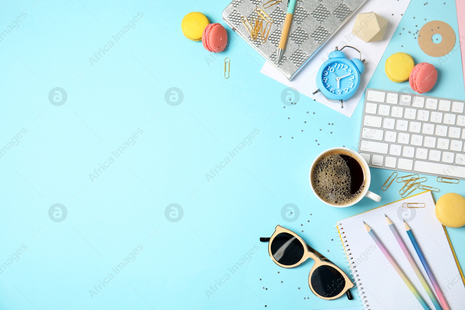 Photo of Flat lay composition with stationery, keyboard, macaroons and space for text on color background. Blogger's workplace