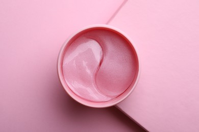 Photo of Package of under eye patches on pink background, top view. Cosmetic product