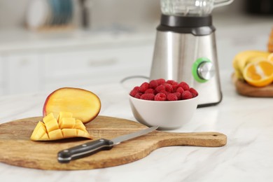 Photo of Cut mango and raspberry on white marble table. Ingredients for smoothie