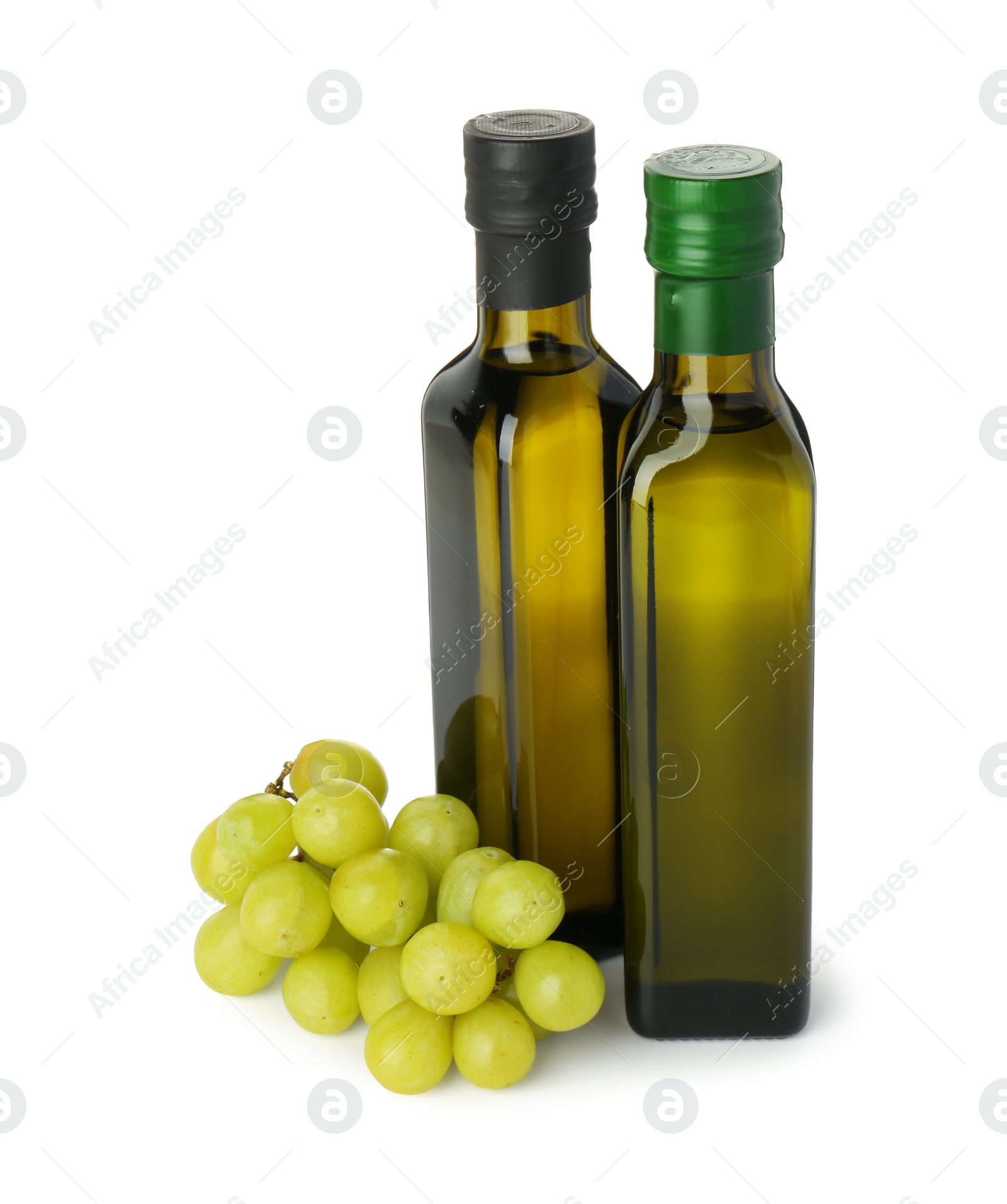 Photo of Vegetable fats. Bottles of cooking oils and fresh grapes isolated on white