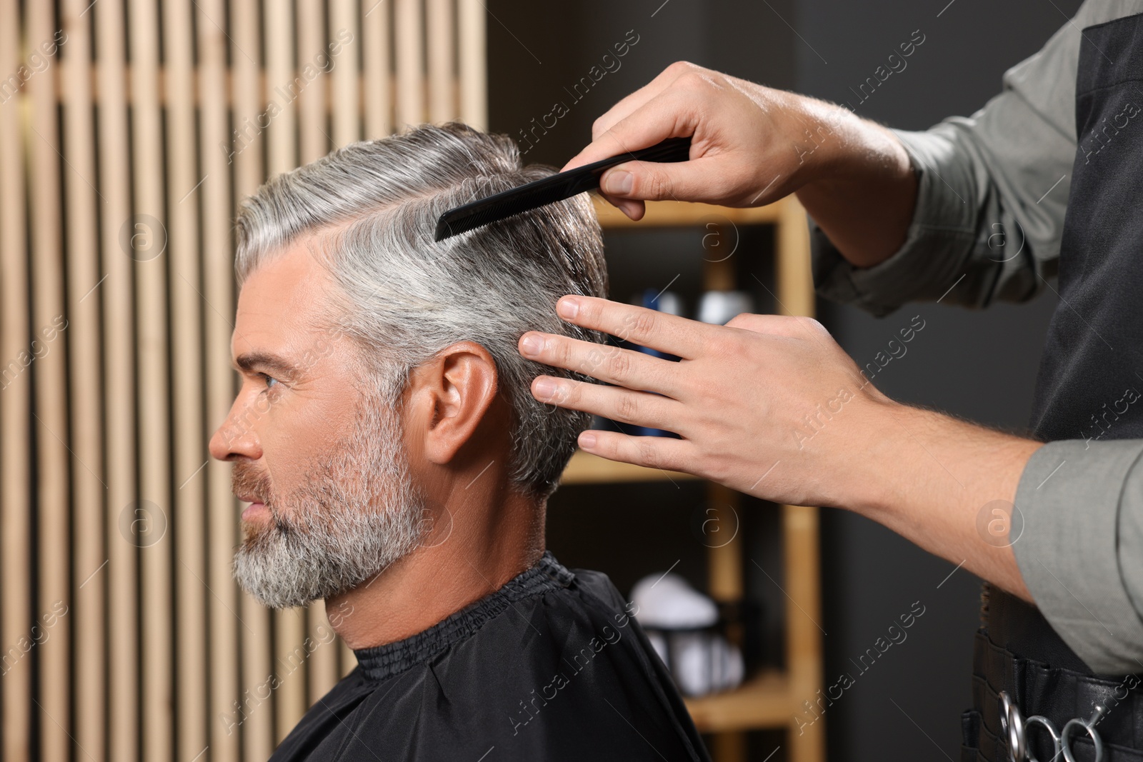 Photo of Hair styling. Professional hairdresser working with client in barbershop, closeup