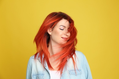 Photo of Young woman with bright dyed hair on yellow background