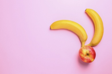 Tasty raw apple and bananas on pink background, flat lay with space for text