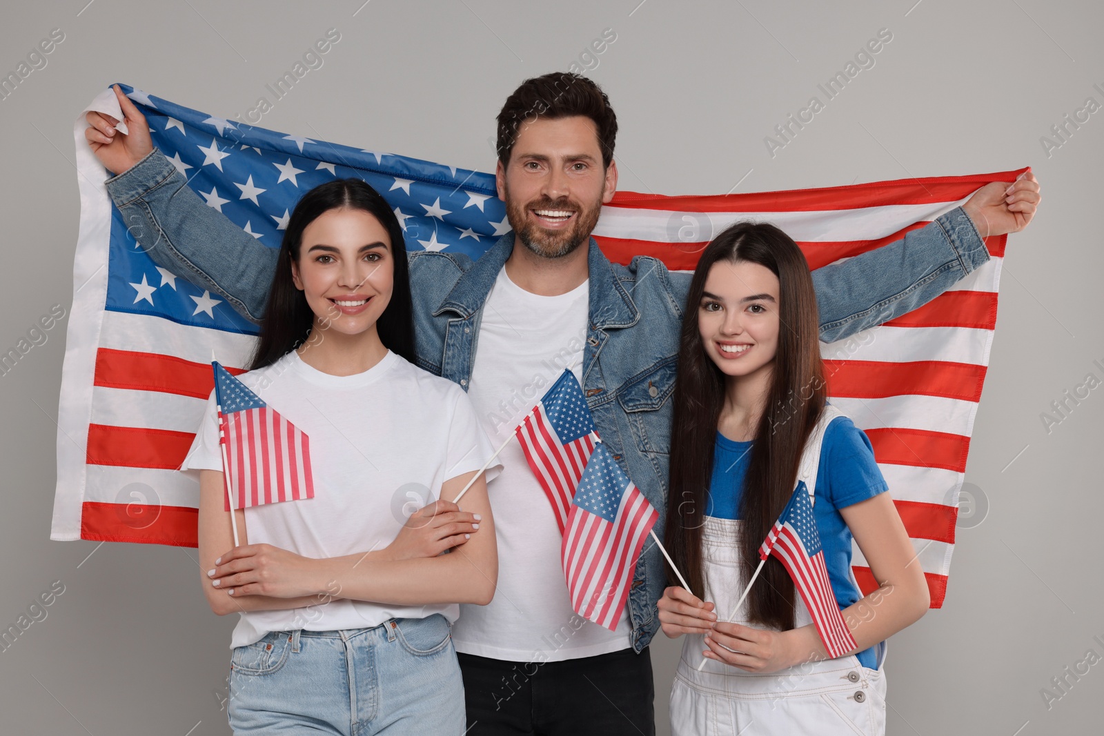 Photo of 4th of July - Independence Day of USA. Happy family with American flags on grey background