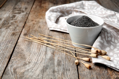 Photo of Composition with poppy seeds on wooden table