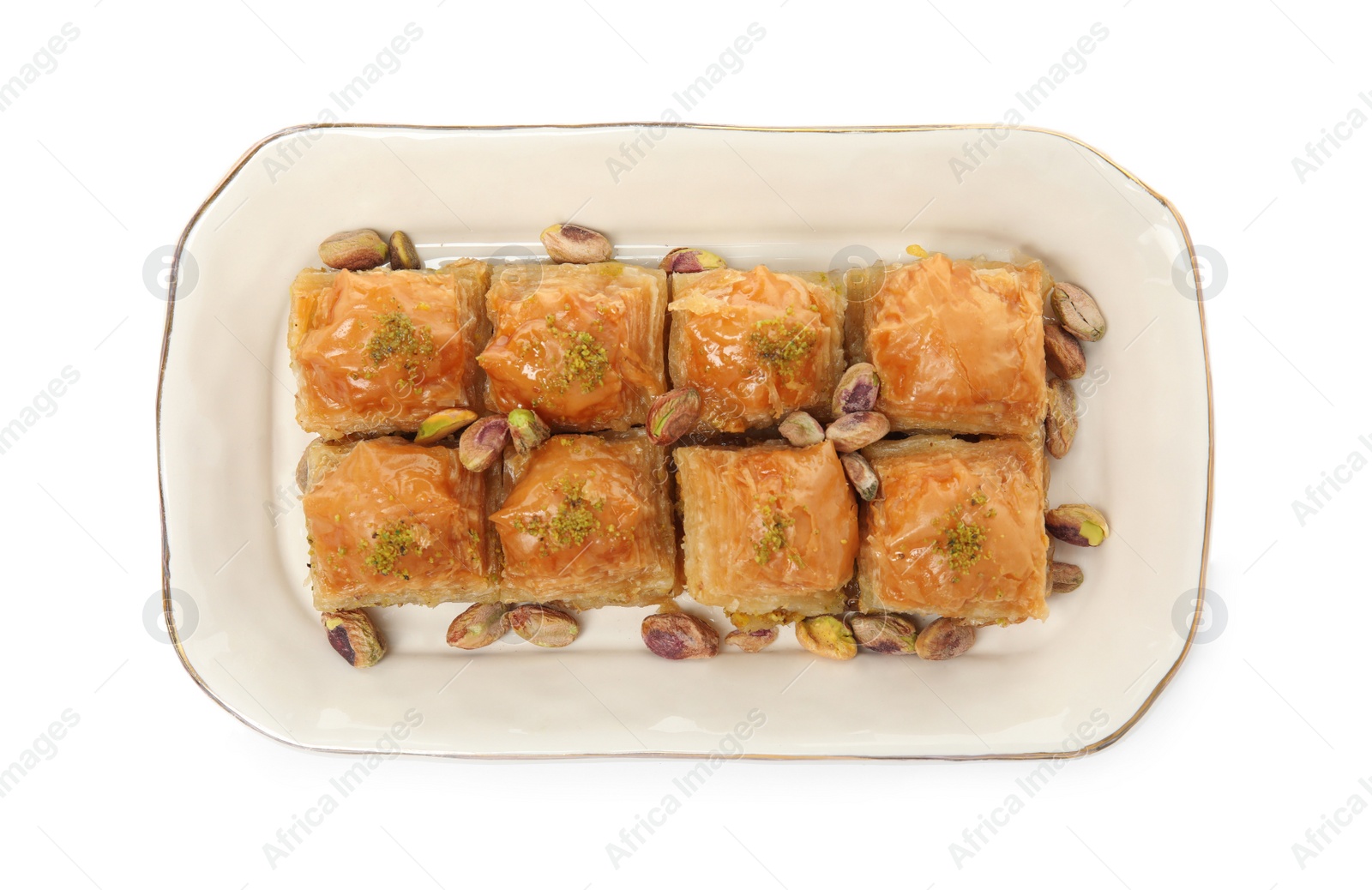 Photo of Plate of delicious baklava with pistachio nuts on white background, top view