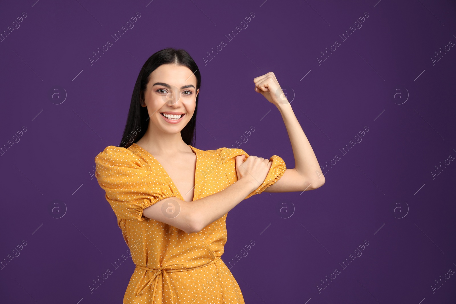 Photo of Strong woman as symbol of girl power on purple background. 8 March concept