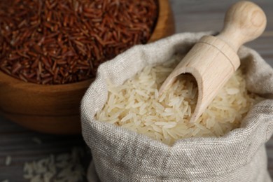 Photo of Bag and bowl with different sorts of rice on table, closeup