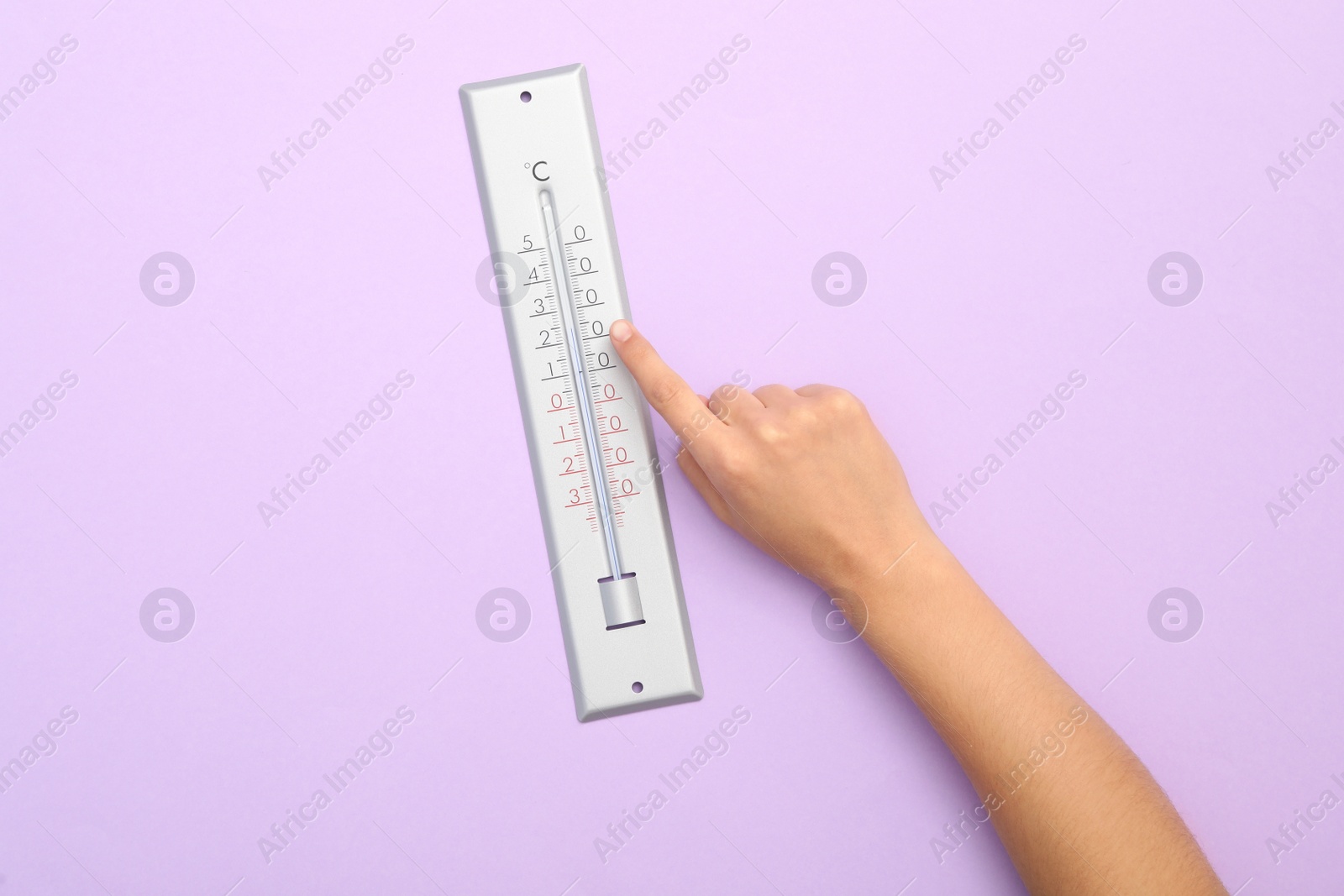 Photo of Woman with weather thermometer on lilac background, top view
