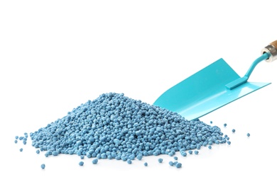 Pile of granular mineral fertilizer with shovel on white background