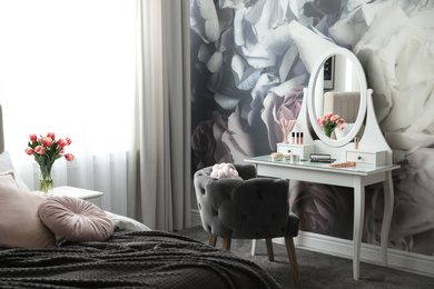Photo of Stylish bedroom interior with elegant dressing table and floral wallpaper
