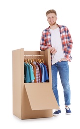 Photo of Young man near wardrobe box on white background