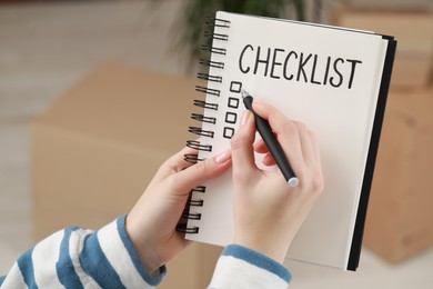 Photo of Woman filling Checklist with pen indoors, closeup. Space for text