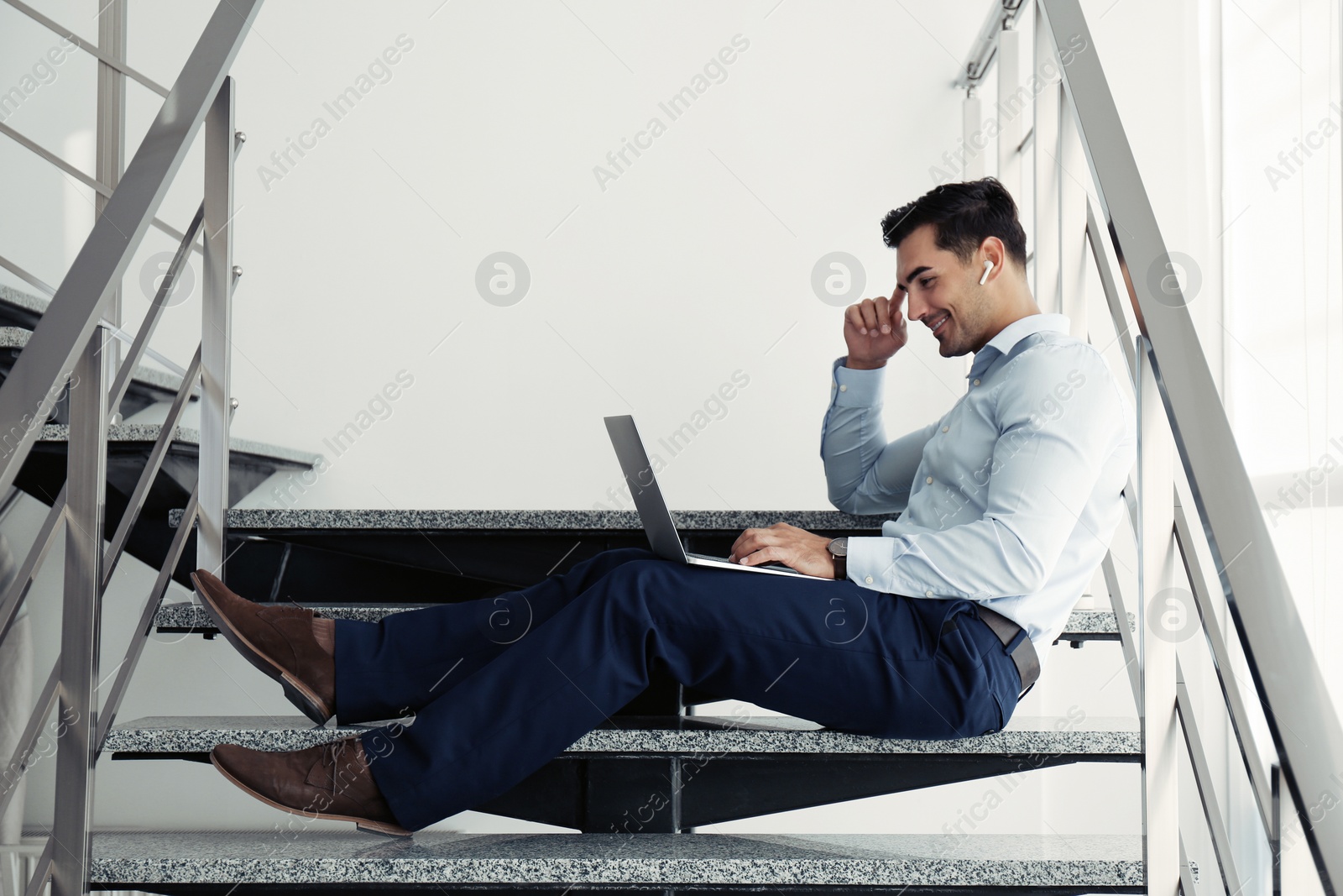 Photo of Portrait of young man with laptop indoors