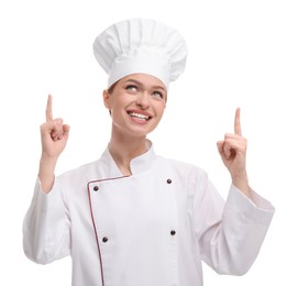 Happy woman chef in uniform pointing at something on white background