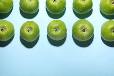 Ripe green apples on light blue background, flat lay. Space for text