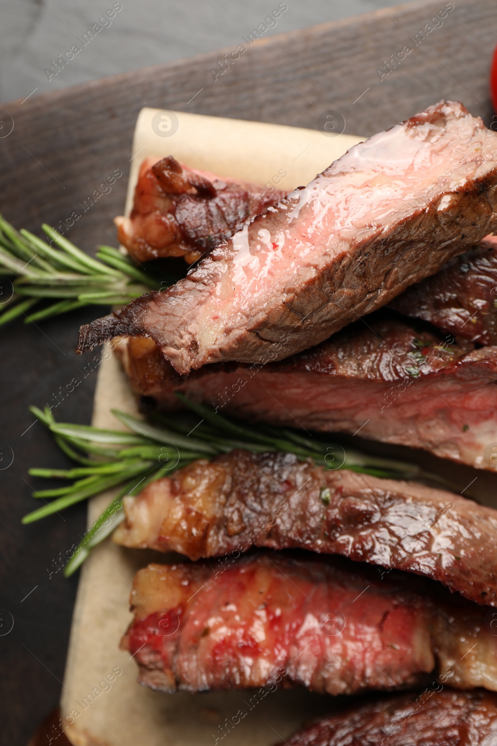 Photo of Delicious grilled beef with rosemary on table, top view