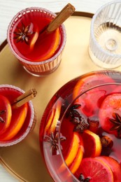 Photo of Glasses and bowl of delicious aromatic punch drink on white wooden table, top view