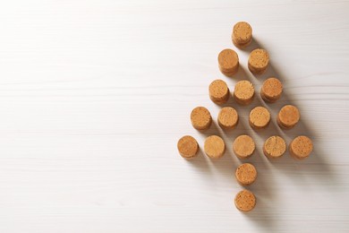 Photo of Christmas tree made of wine corks on white wooden table, top view. Space for text