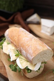 Tasty sandwich with brie cheese on table, closeup. Space for text