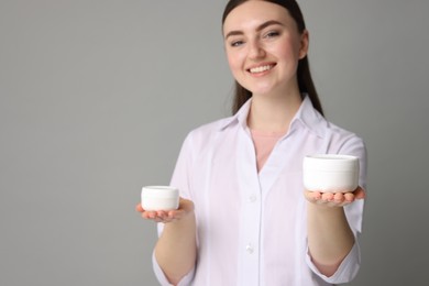 Photo of Cosmetologist with cosmetic products on grey background, selective focus. Space for text