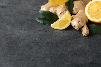 Photo of Fresh lemon and ginger on grey table. Space for text