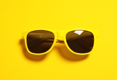 Photo of Stylish sunglasses on color background, top view. Beach accessories