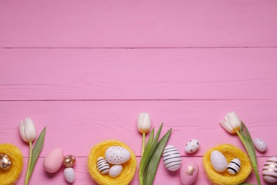 Photo of Flat lay composition of painted Easter eggs and tulip flowers on pink wooden table. Space for text
