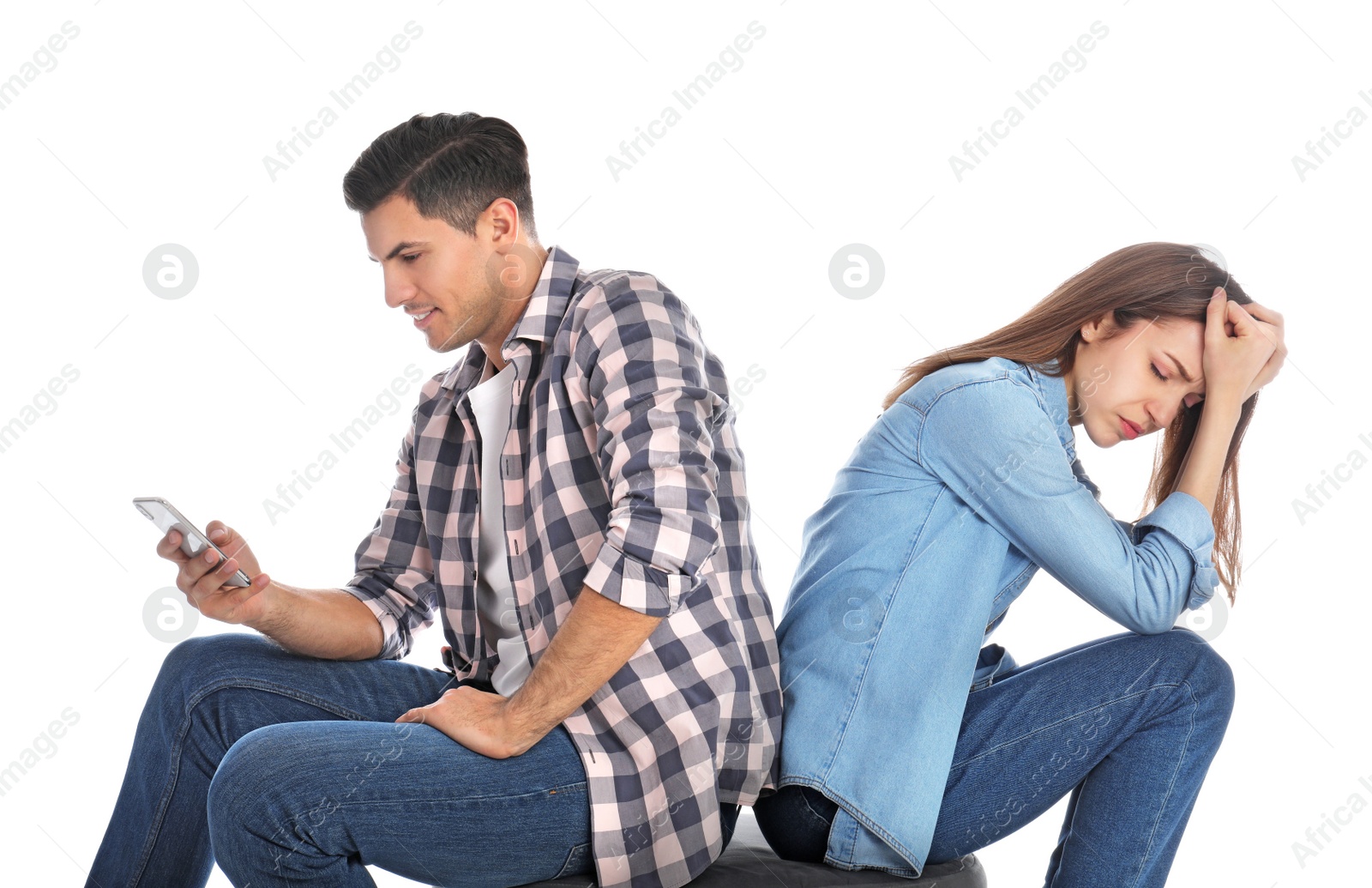 Photo of Man with smartphone ignoring his girlfriend on white background. Relationship problems