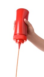 Woman pouring tasty ketchup from bottle on white background, closeup