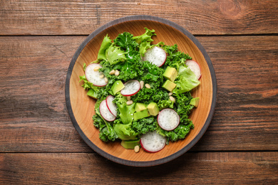 Photo of Delicious kale salad on wooden table, top view