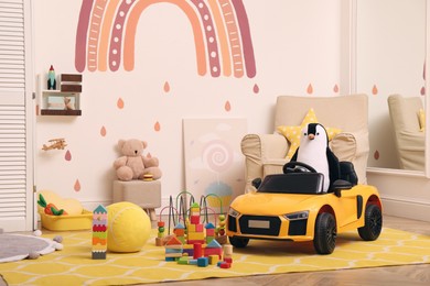 Child's electric car and other toys in playroom