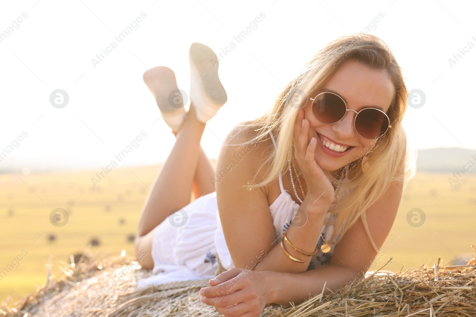 Photo of Beautiful hippie woman on hay bale in field