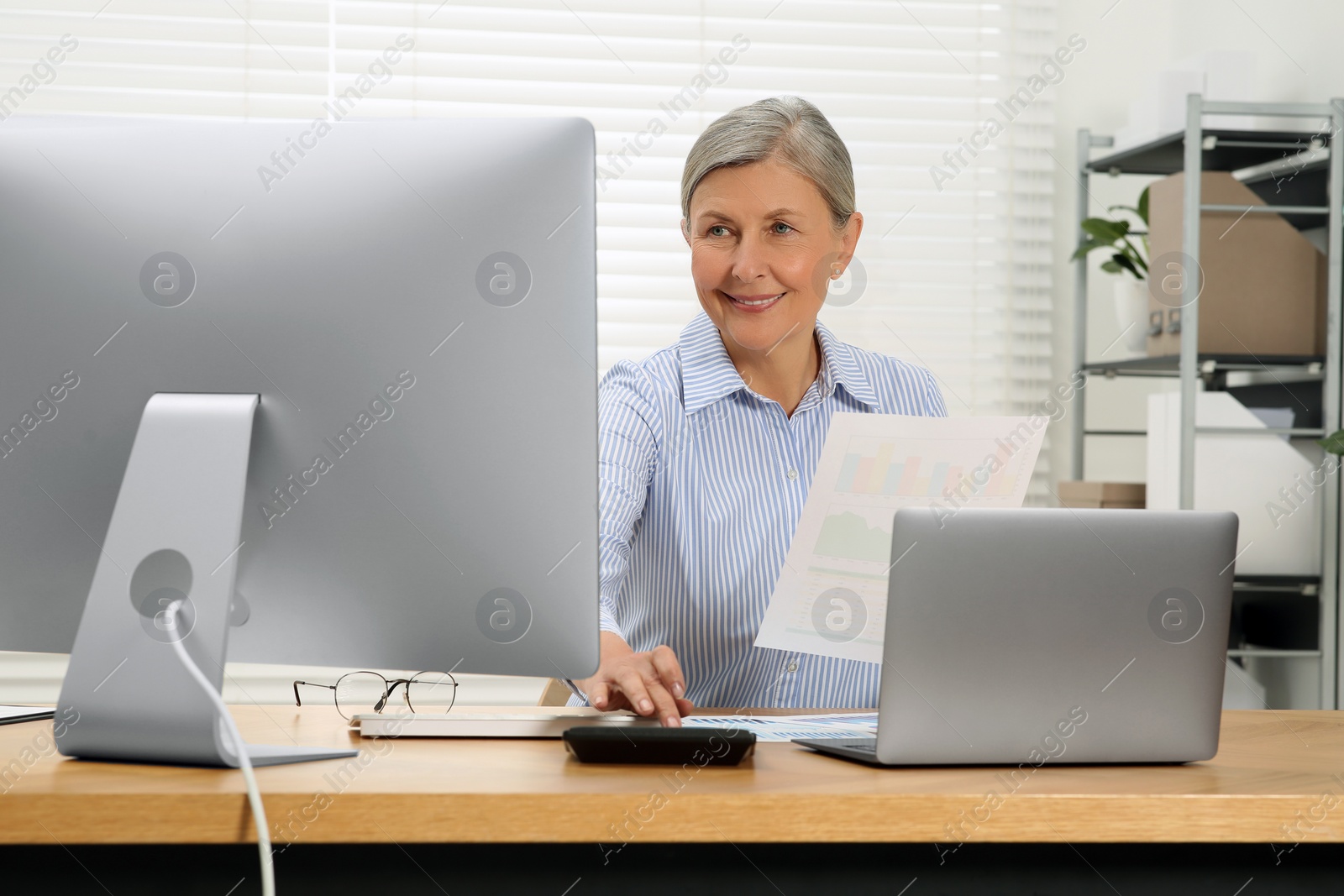 Photo of Senior accountant working at wooden desk in office