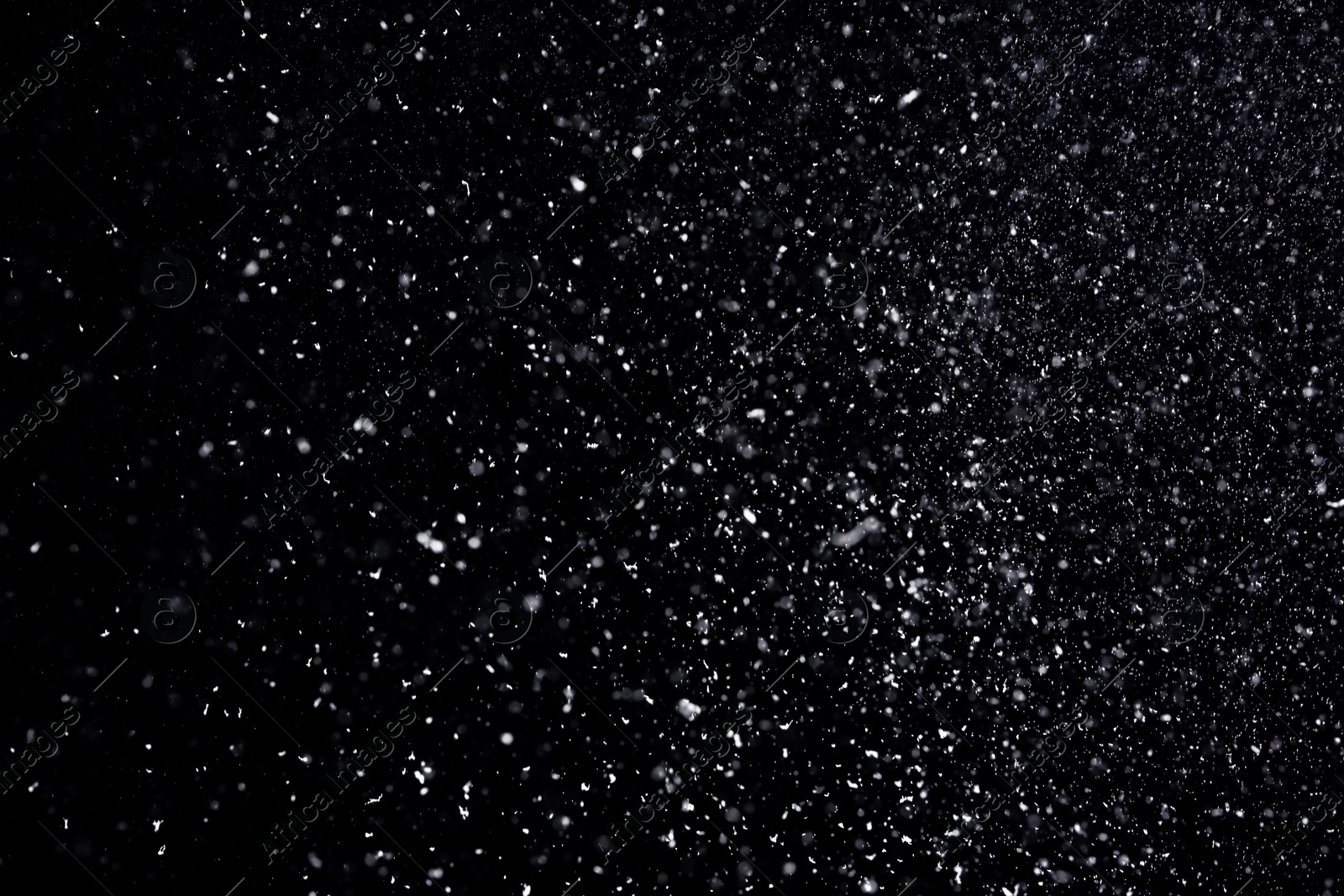 Photo of Snow flakes falling on black background. Winter weather