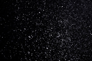 Photo of Snow flakes falling on black background. Winter weather