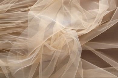 Photo of Beautiful tulle fabric on brown background, top view